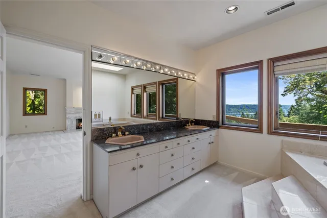 a bathroom with a granite countertop sink and a window