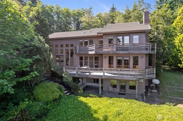 an aerial view of a house with swimming pool next to a yard