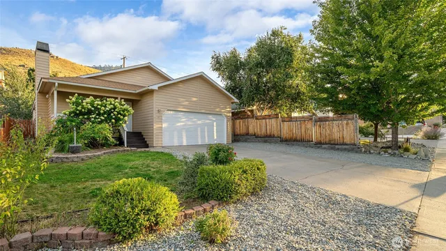 a view of a house with a yard and wooden fence