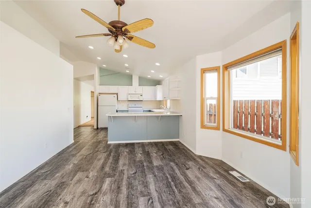 a view of a kitchen with wooden floor and a ceiling fan