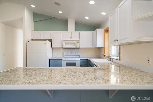 a kitchen with kitchen island a stove a sink and a refrigerator