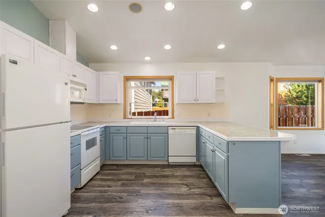 a kitchen with white cabinets and white appliances
