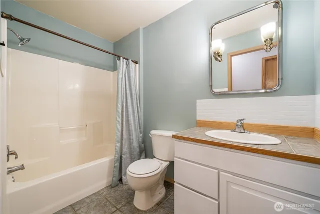 a bathroom with a sink a toilet and a mirror