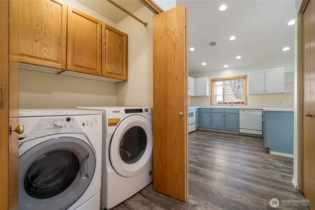 a view of a kitchen with fridge and wooden floor