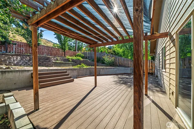 a porch with wooden floor next to a yard