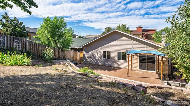 a front view of a house with a yard and potted plants