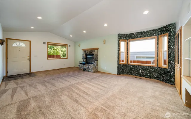 a view of an empty room with a window and a bathroom