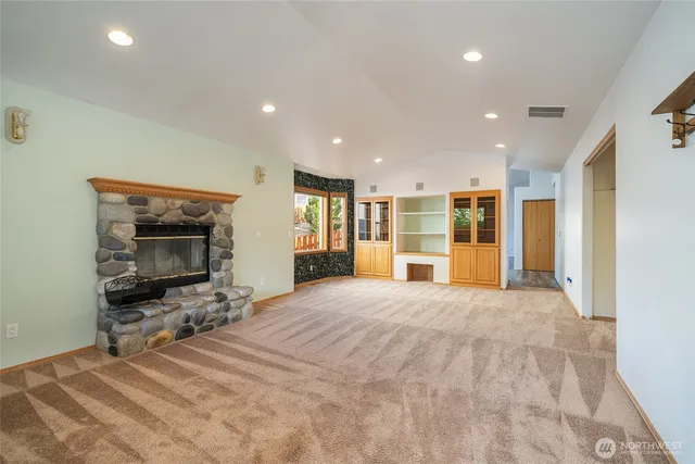 a large bedroom with a bed and a view of kitchen