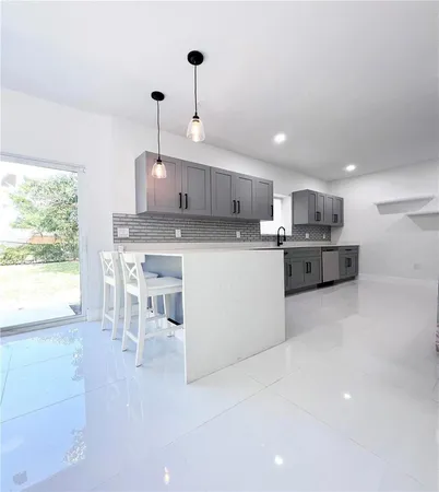 a kitchen with kitchen island a stove a table and chairs in it