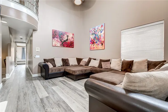 a living room with couches and a night stand with wooden floor
