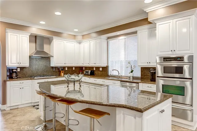 a kitchen with stainless steel appliances granite countertop a stove a sink a microwave a dining table and chairs