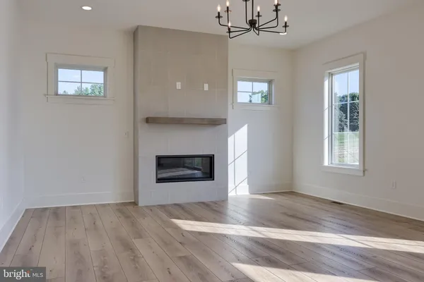 a view of an empty room with window and fire place