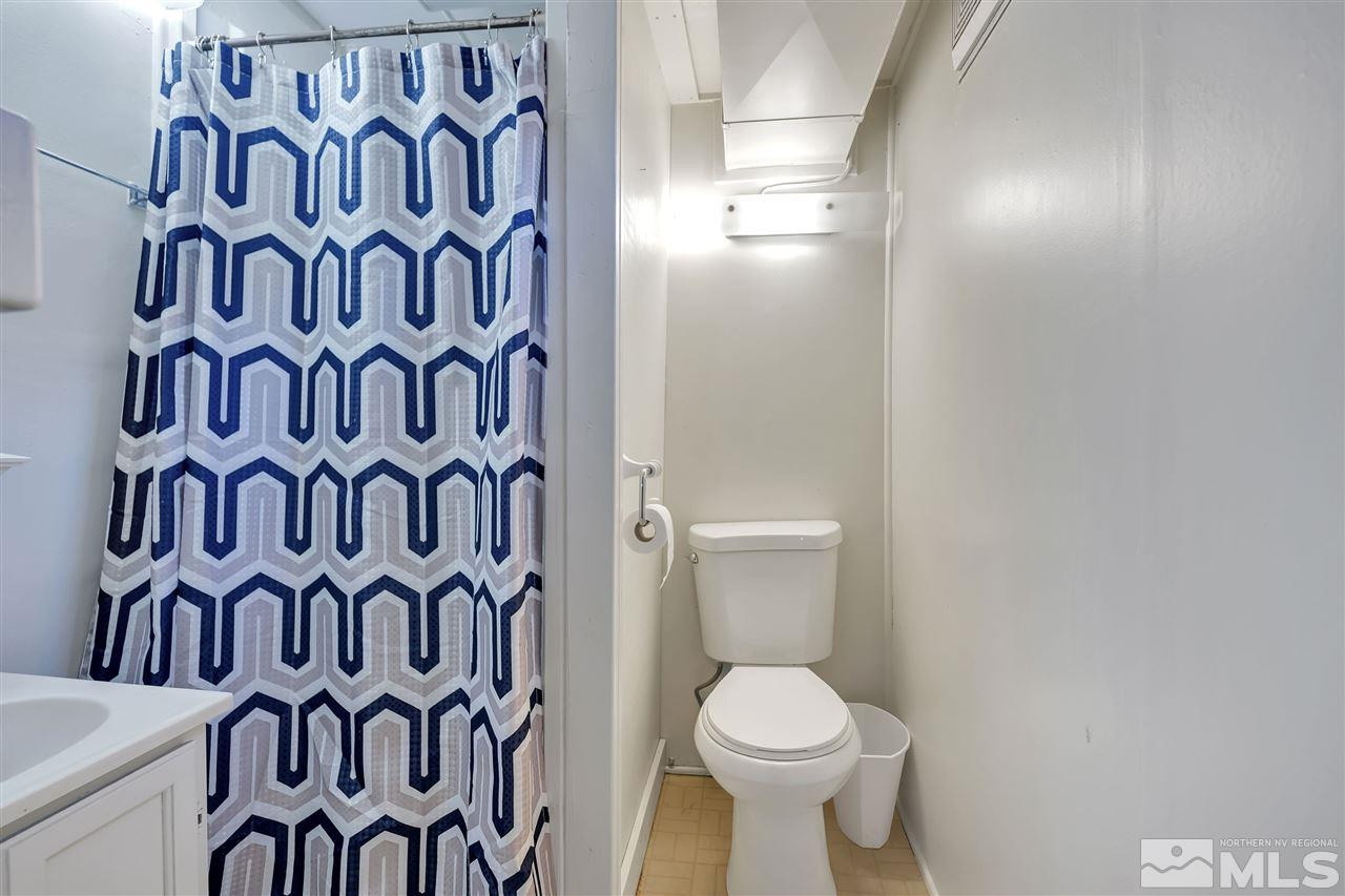 1135 The Strand Reno, NV 89503 - Photo 16 of 33 a white toilet sitting next to a shower curtain