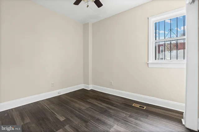 a view of empty room with wooden floor