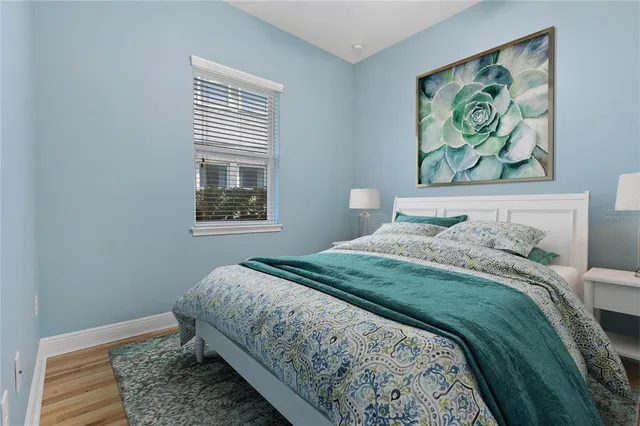 a bedroom with bed and wall painting with wooden floor