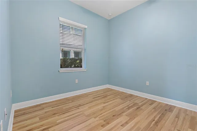 a view of a big room with wooden floor and windows
