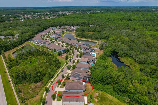 an aerial view of residential houses with outdoor space and trees