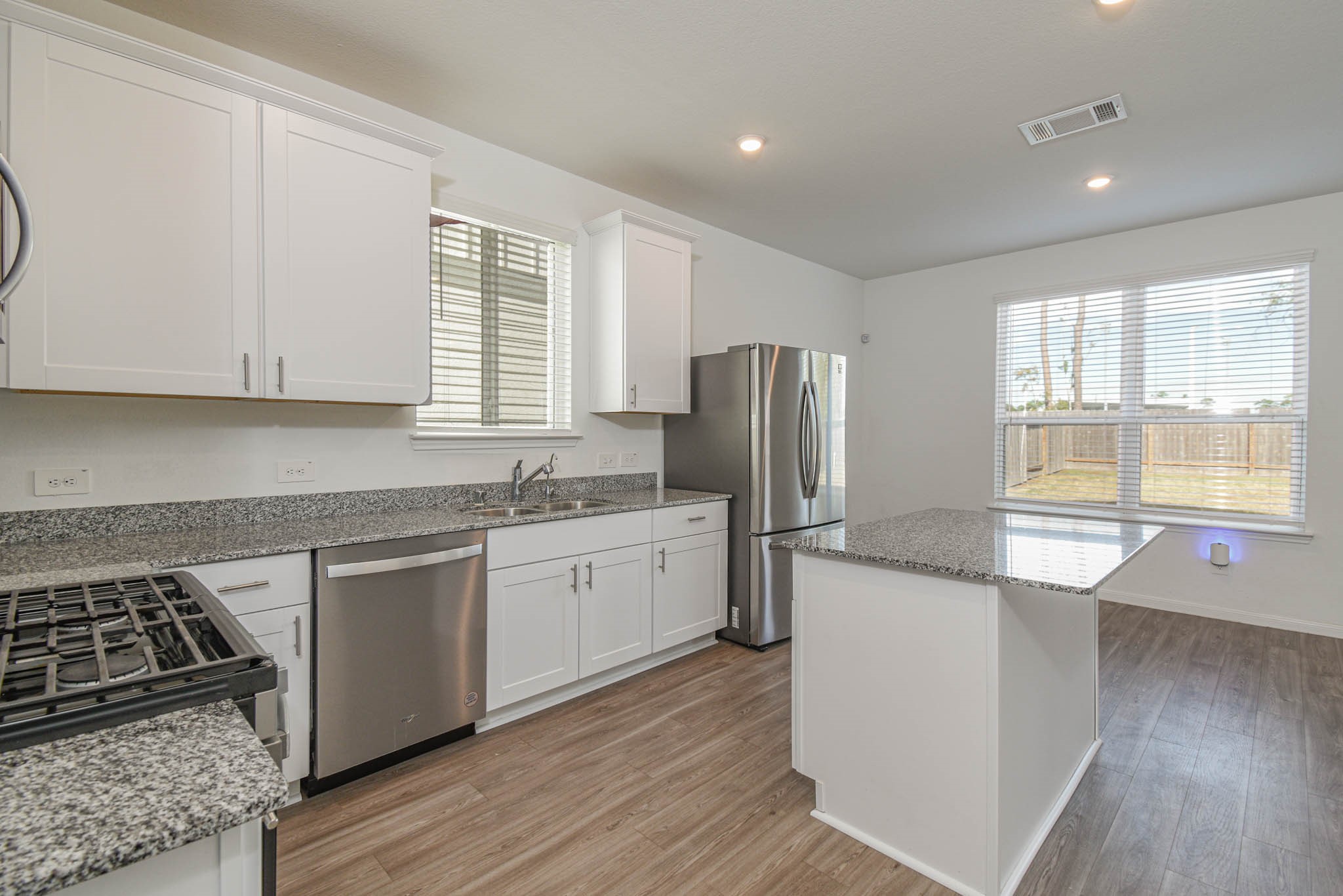 5727 Finely Run Street Spring, TX 77373 - Photo 7 of 26 a kitchen with a refrigerator and wooden cabinets