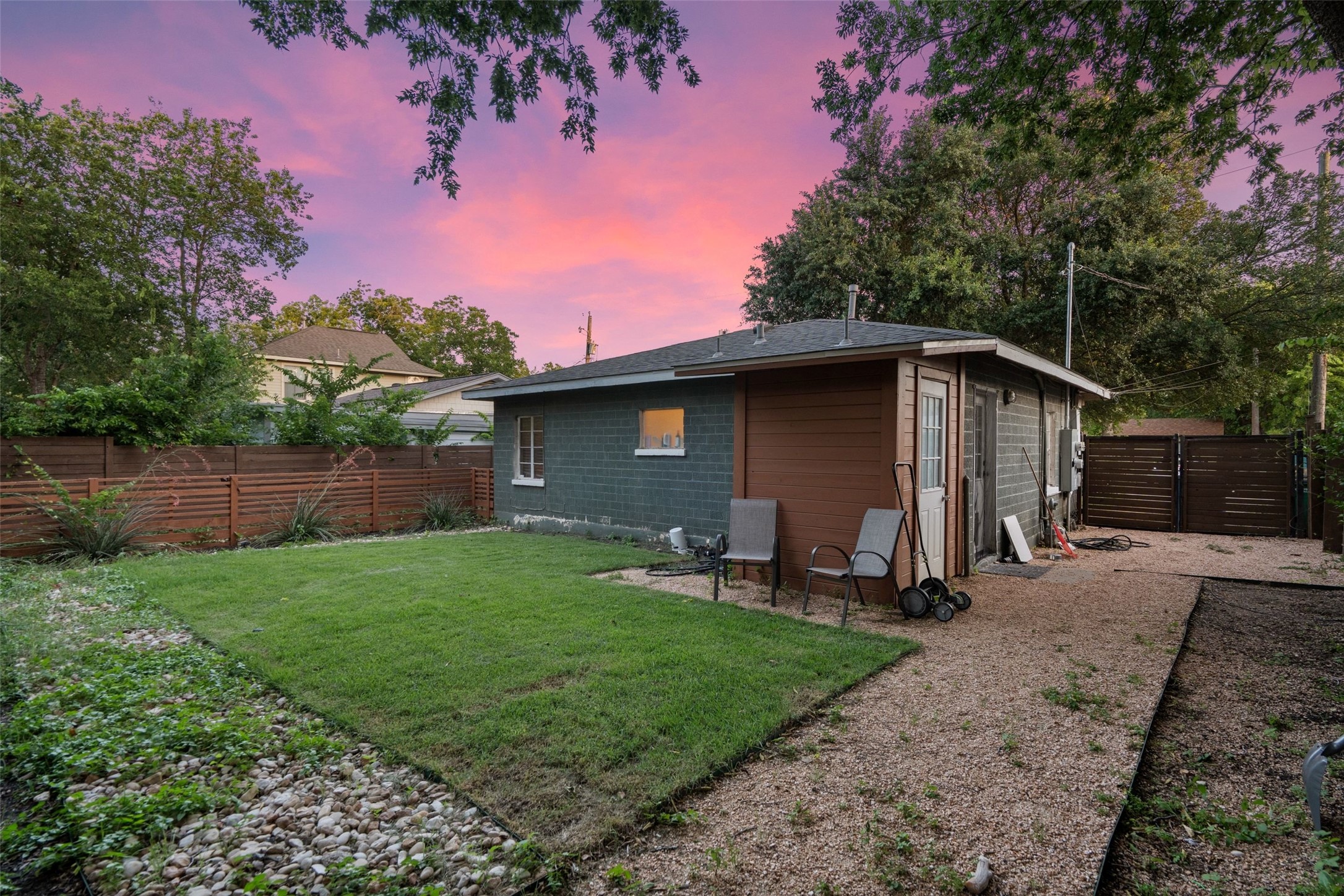 412 West Croslin Street Austin, TX 78752 - Photo 17 of 36 A private backyard oasis offers a lush lawn alongside a versatile outbuilding.