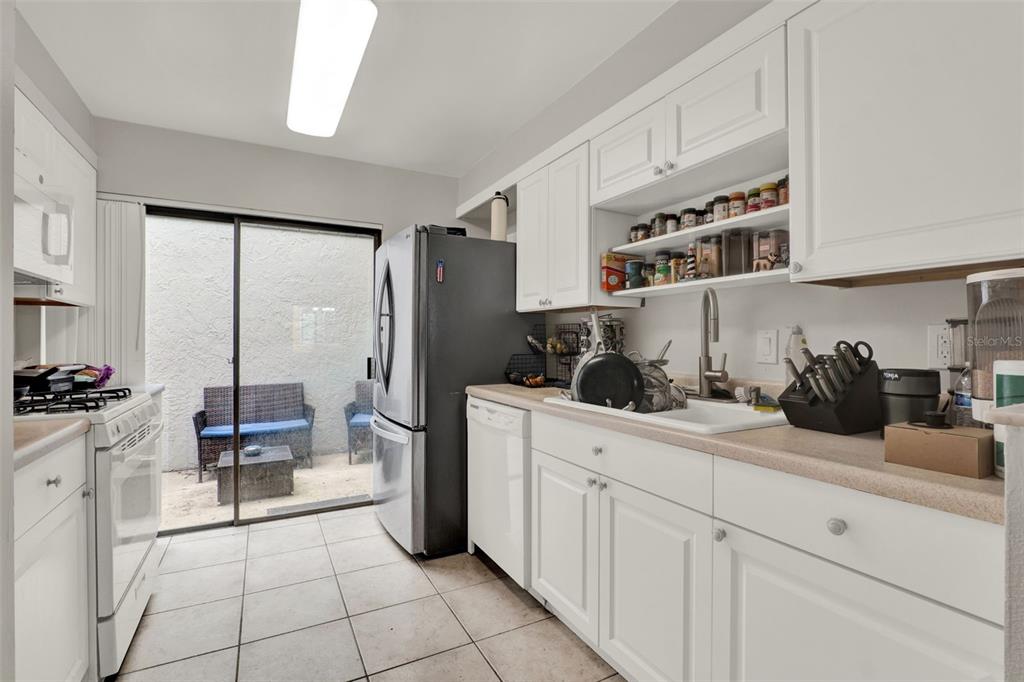 212 Perth Court Winter Springs, FL 32708 - Photo 13 of 57 a kitchen with a sink dishwasher stove and white cabinets with wooden floor