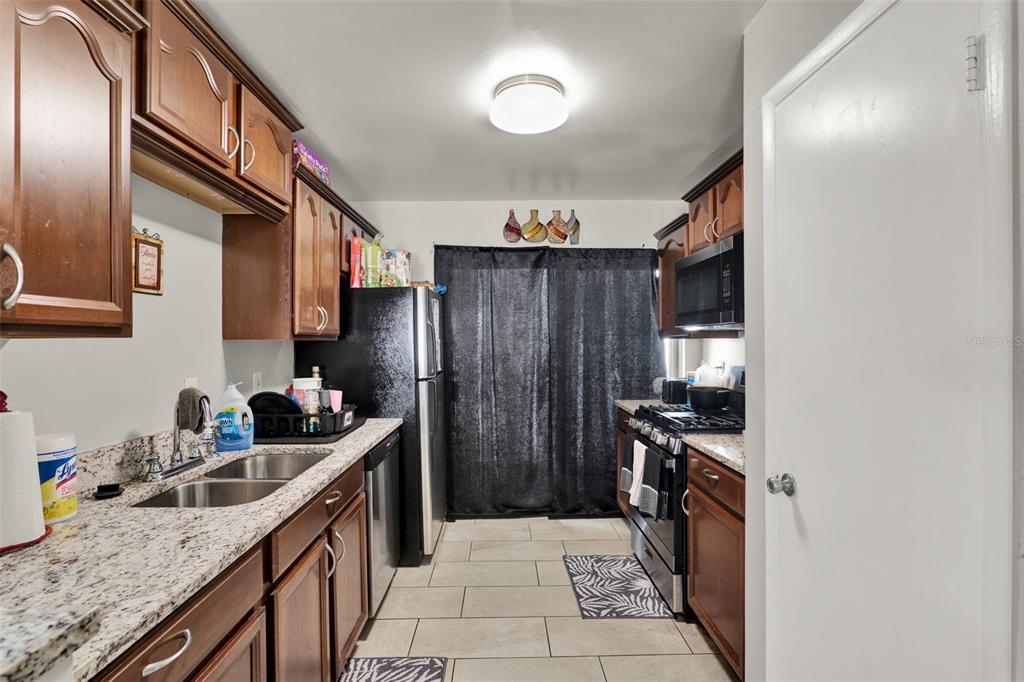 212 Perth Court Winter Springs, FL 32708 - Photo 41 of 57 a kitchen with stainless steel appliances granite countertop a sink stove and refrigerator