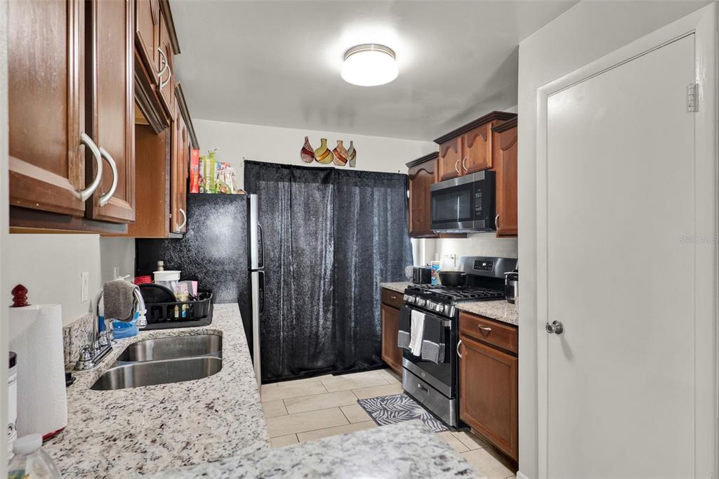 212 Perth Court Winter Springs, FL 32708 - Photo 43 of 57 a kitchen with stainless steel appliances granite countertop a refrigerator stove and oven