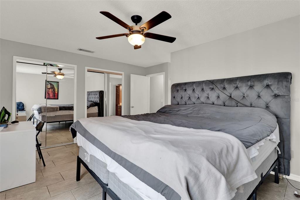 212 Perth Court Winter Springs, FL 32708 - Photo 46 of 57 a spacious bedroom with a bed a dresser and a chandelier