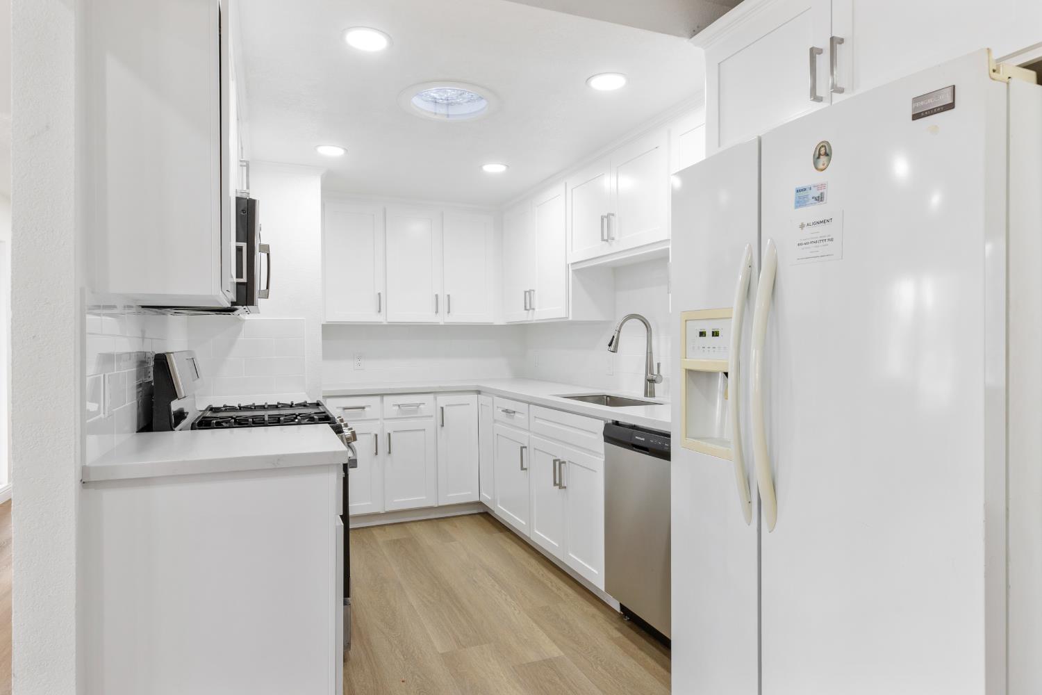 3020 Trudi Way Modesto, CA 95354 - Photo 8 of 24 a kitchen with stainless steel appliances granite countertop a sink a stove a refrigerator and white cabinets