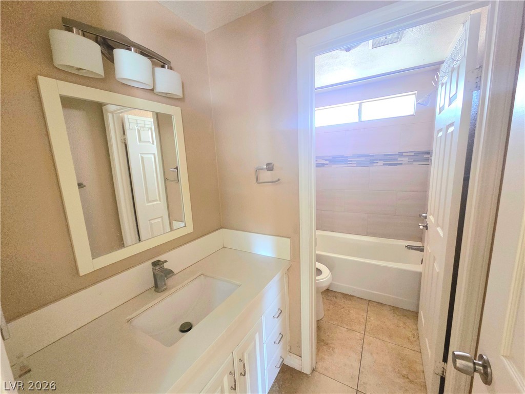 3648 Bronco Road Las Vegas, NV 89103 - Photo 22 of 24 A pristine bathroom featuring a sleek vanity and a tiled shower-tub combination.