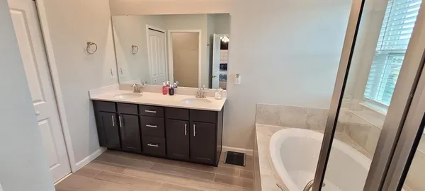 a bathroom with a sink a mirror a vanity and a shower