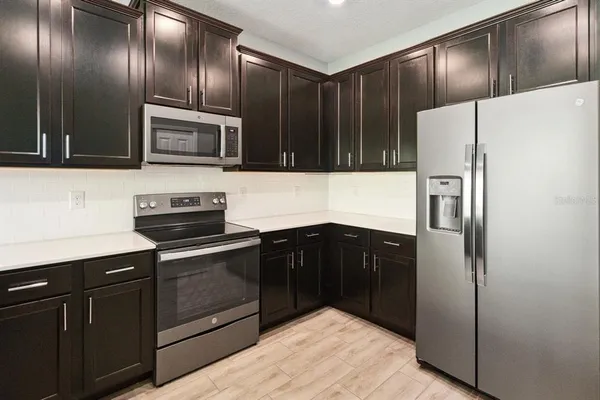 a kitchen with granite countertop stainless steel appliances and wooden cabinets