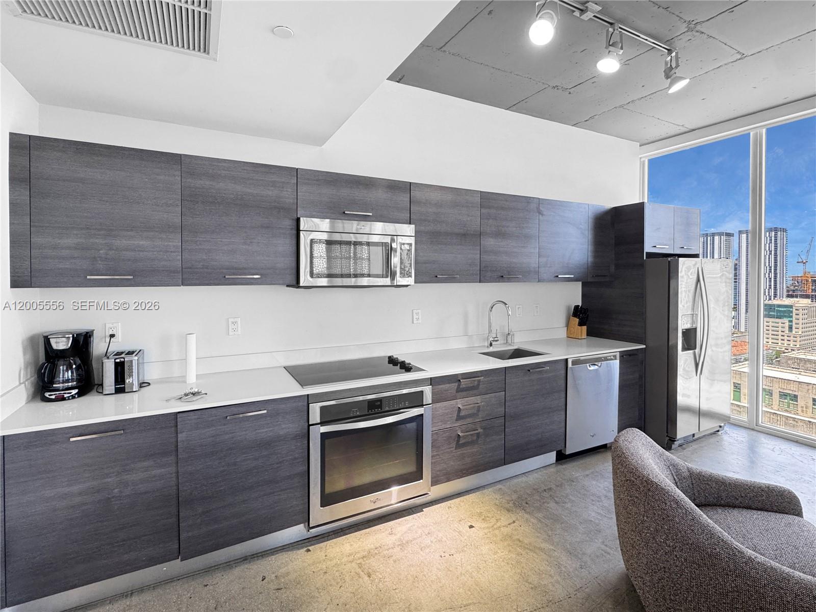 151 Southeast 1st Street, Unit 2702 Miami, FL 33131 - Photo 5 of 29 a kitchen with stainless steel appliances granite countertop a sink stove and refrigerator