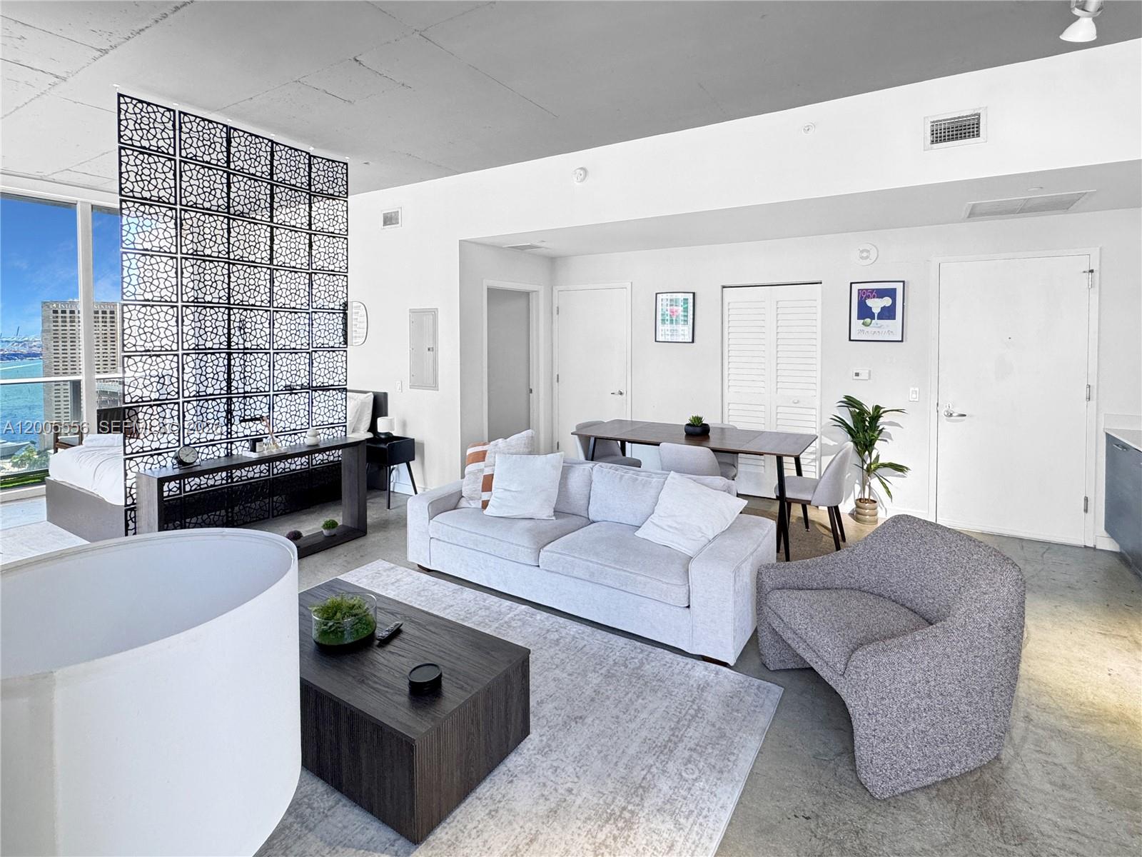 151 Southeast 1st Street, Unit 2702 Miami, FL 33131 - Photo 6 of 29 a living room with furniture and a potted plant