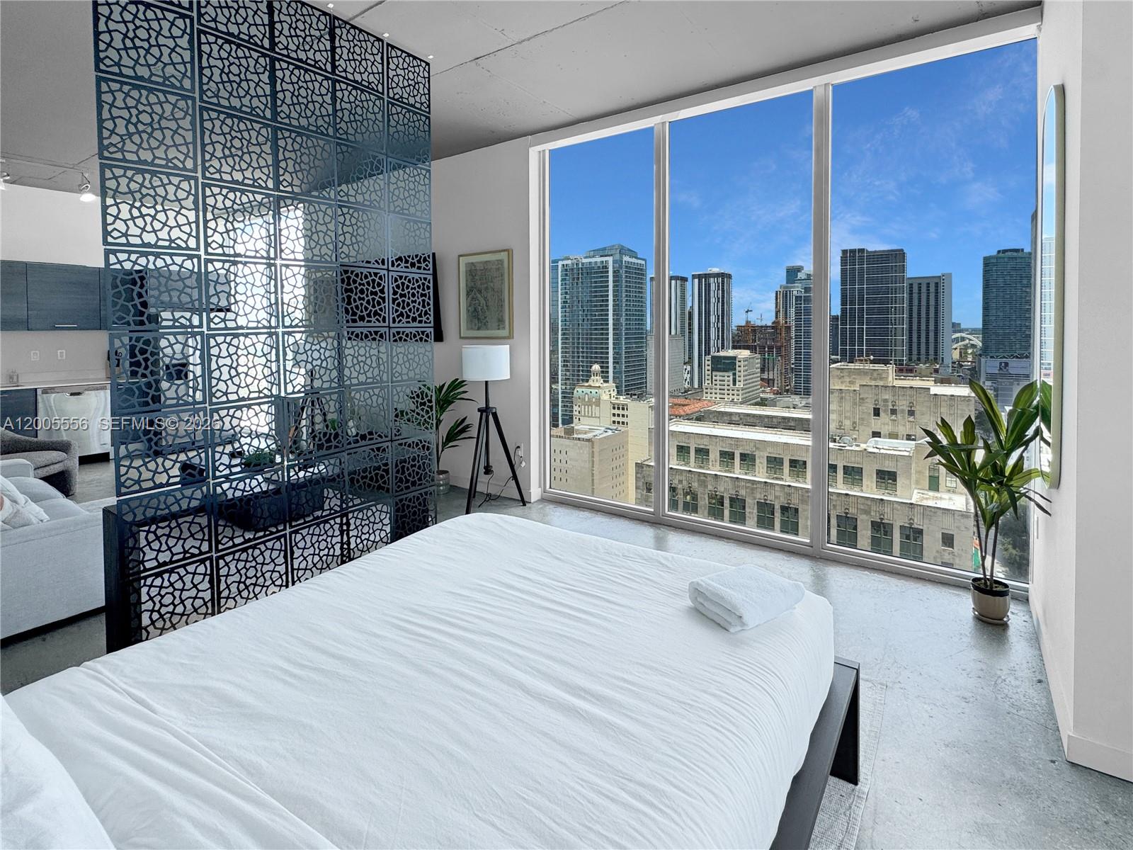 151 Southeast 1st Street, Unit 2702 Miami, FL 33131 - Photo 9 of 29 a room with a bed a table a flat screen tv and windows