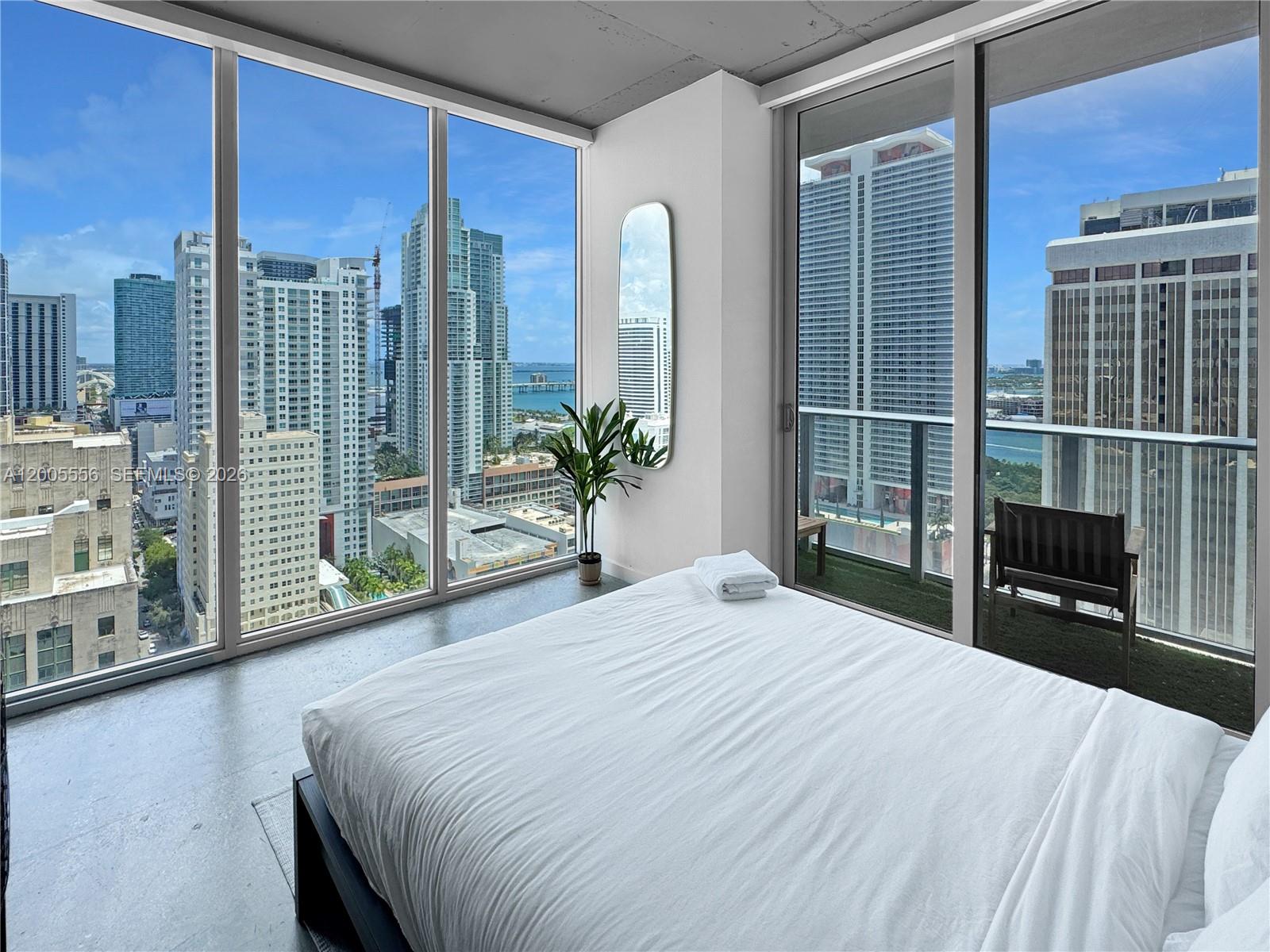151 Southeast 1st Street, Unit 2702 Miami, FL 33131 - Photo 10 of 29 a bedroom with a large bed and a large window