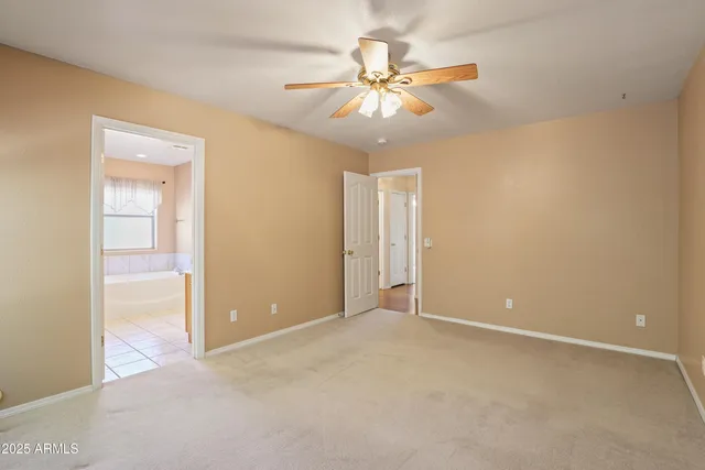 an empty room with closet and a chandelier fan