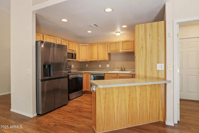 a kitchen with a refrigerator sink and cabinets