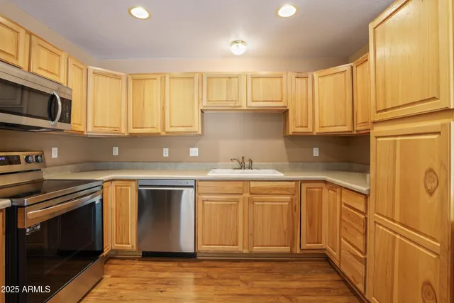 a kitchen with stainless steel appliances granite countertop a stove a sink and a refrigerator