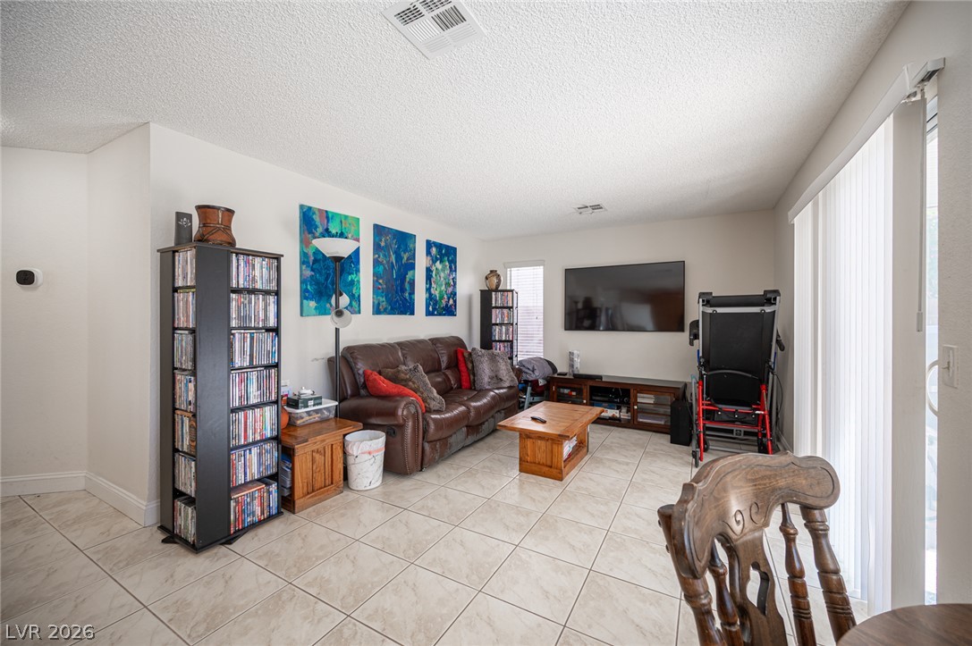 718 Rusty Spur Drive Henderson, NV 89014 - Photo 13 of 50 The living room offers tiled flooring throughout, providing a durable and easily maintainable space.