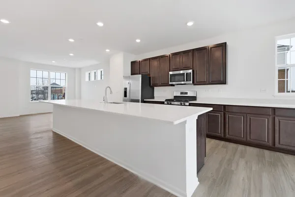 a kitchen with stainless steel appliances a microwave a sink a stove a refrigerator and cabinets