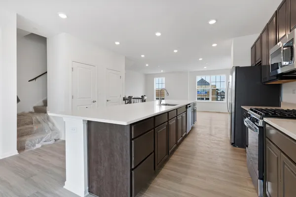 a large kitchen with stainless steel appliances kitchen island granite countertop a large counter top and wooden floors