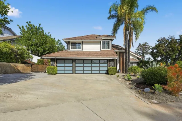 front view of a house with a yard and a garage