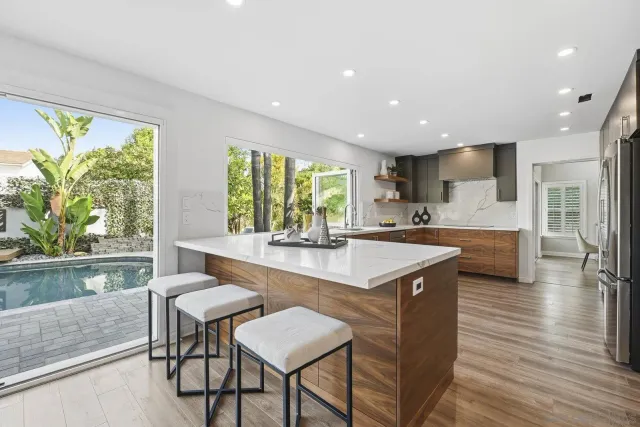a kitchen with stainless steel appliances granite countertop a sink and a large refrigerator
