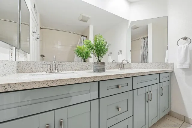 a bathroom with double sink and a mirror
