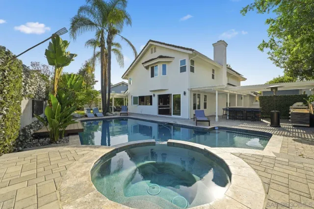 a living room with furniture a flat screen tv and kitchen view