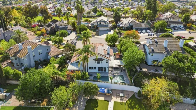 an aerial view of residential houses with outdoor space and trees