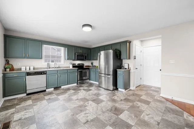 a kitchen with stainless steel appliances granite countertop a refrigerator sink and stove