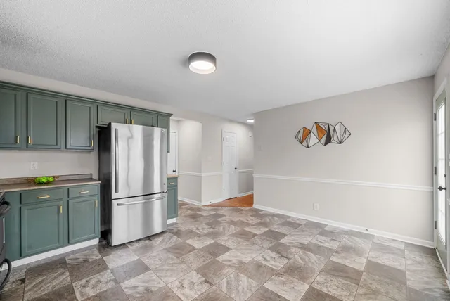 a view of kitchen with refrigerator cabinets and wooden floor