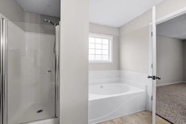 a white bath tub sitting next to a shower