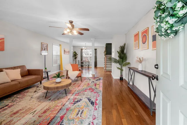 a living room with furniture a piano and a bookshelf